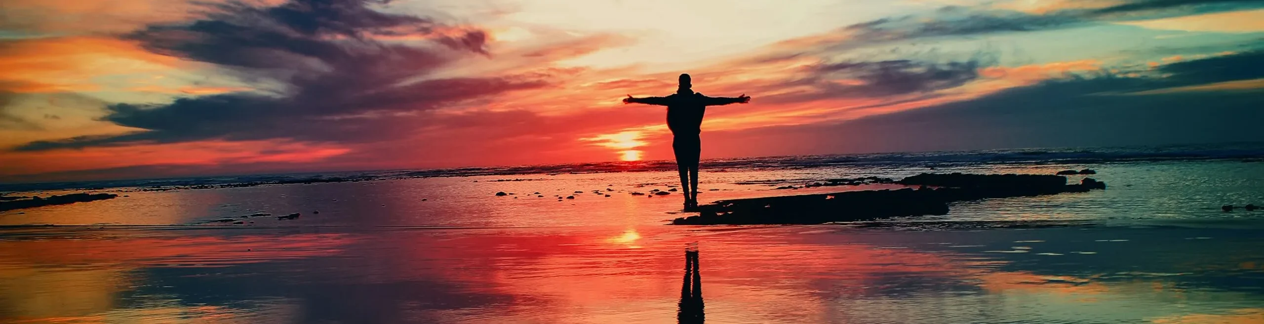 Man Standing On Beach Sunset Scaled 1 Aspect Ratio 1440 370 5